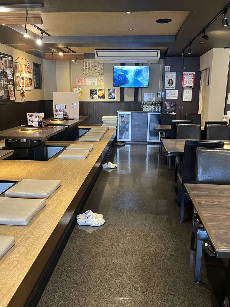 焼肉 ジナンの店内。左手が掘りごたつ席、右手が椅子のテーブル席